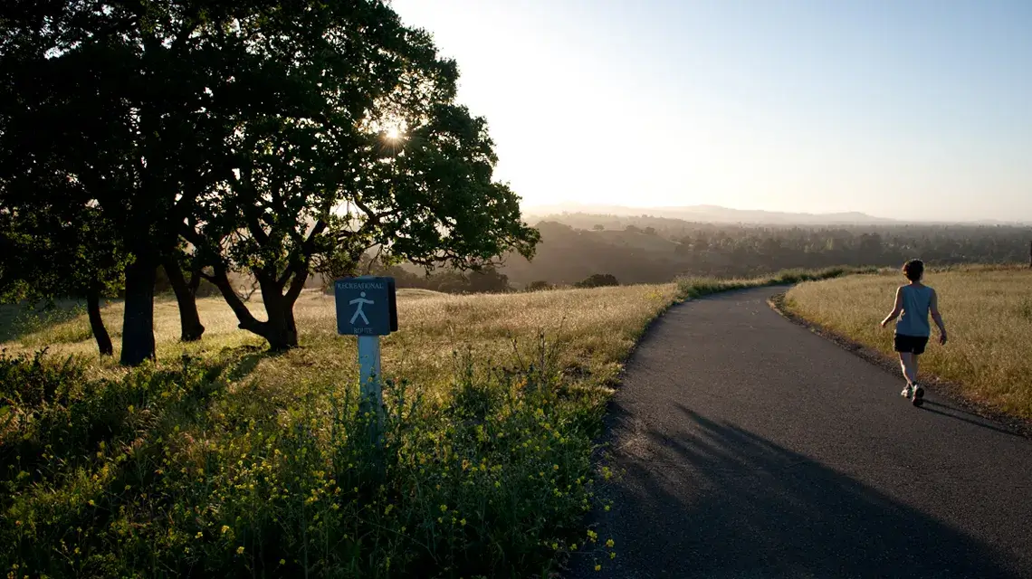 Woman walking on The Dish trail at sunset
