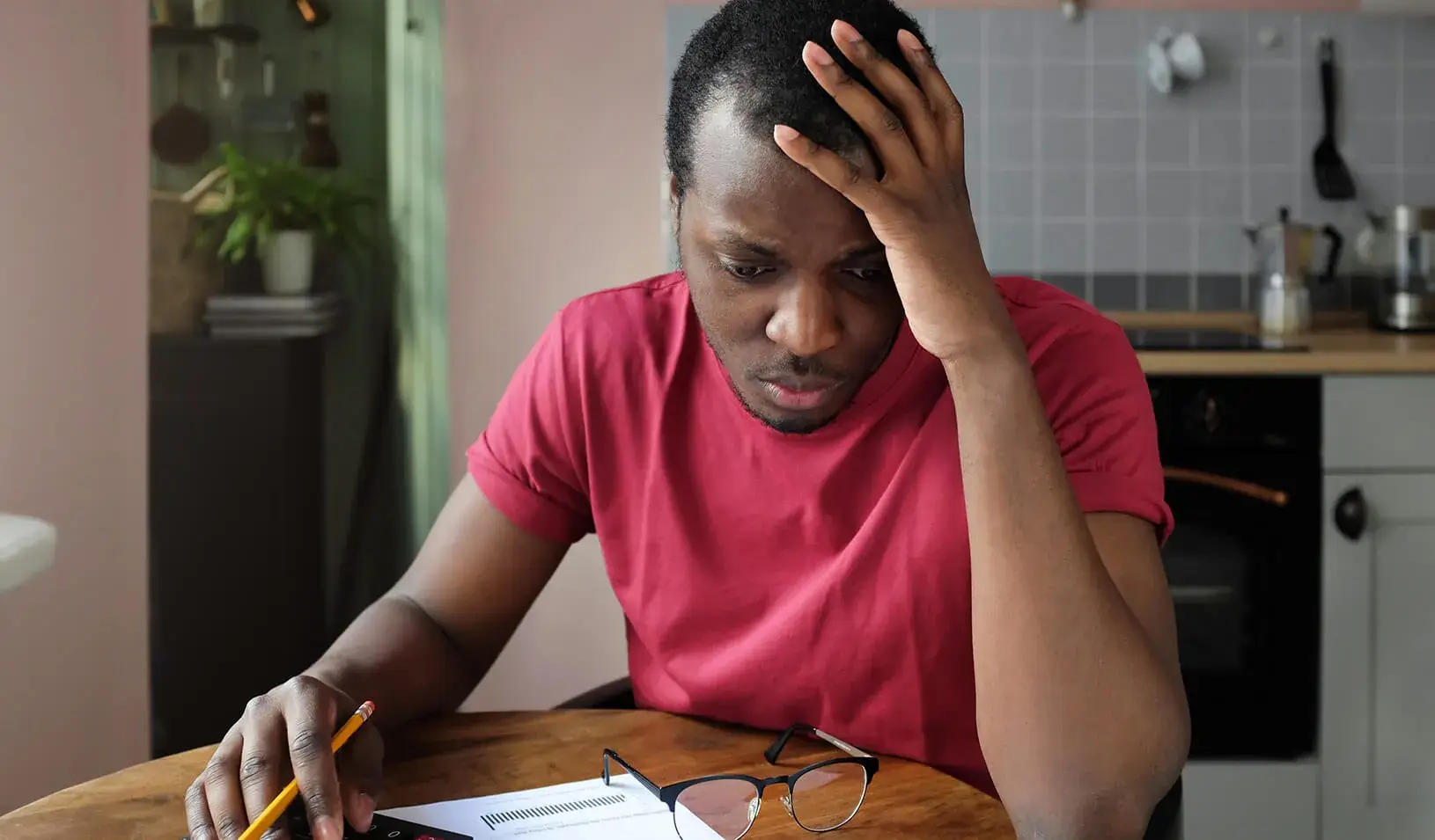 A young Black man, anxious about his bills. Credit: iStock/Damir Khabirov