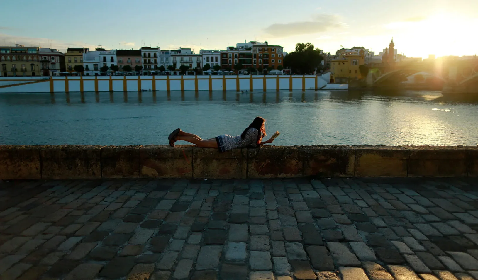 A woman leisurely reading a book. Reuters | Marcelo del Pozo