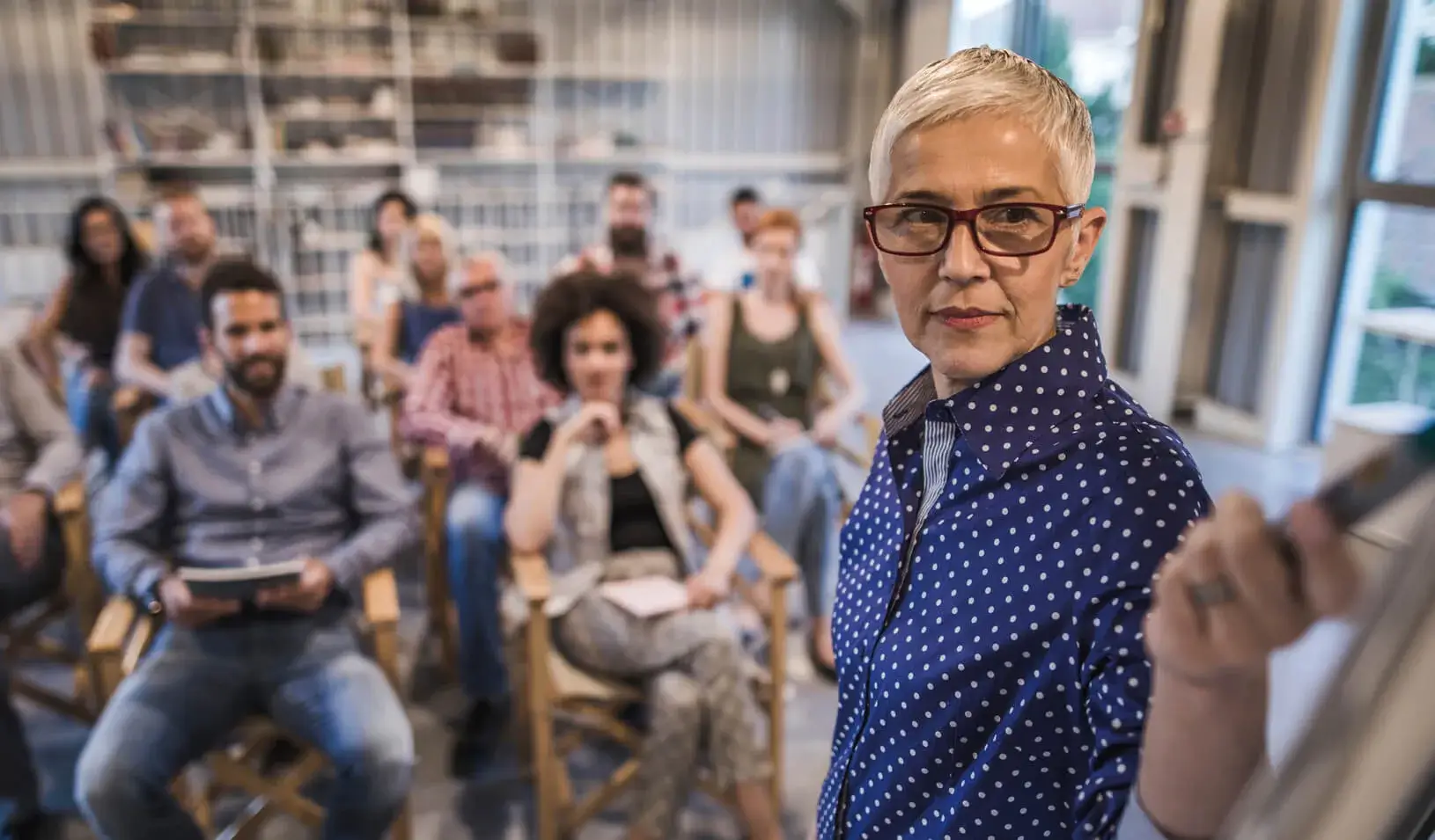 An older businesswoman giving a presentation. Credit: iStock/skynesher