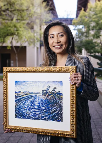 Szu-Chi holding the painting that normally hangs in her office. Credit: Elena Zhukova