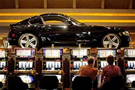 Two individuals sitting at slot machines