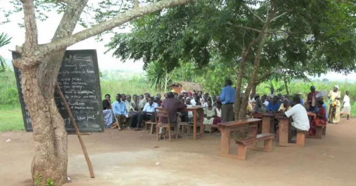 A group of Ugandan farmers gather for a training class.