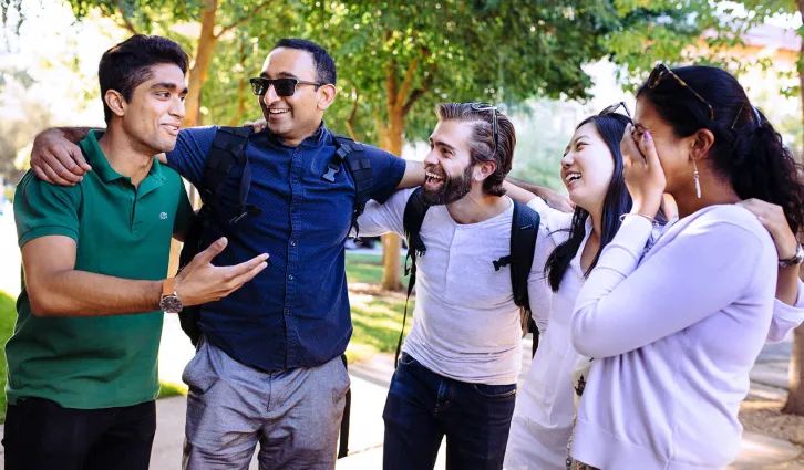 Five students talk and laugh together. Credit: Elena Zukhova