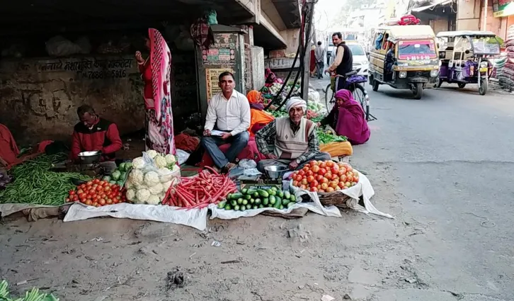 A vendor sells fresh produce at one of the research team’s shops as a surveyor records details of all transactions. Credit: Shashank Sreedharan