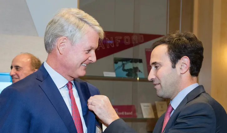 Stanford GSB Dean Jonathan Levin pins 2017 Arbuckle Award recipient John Donahoe, MBA '86. | Stacy Geiken