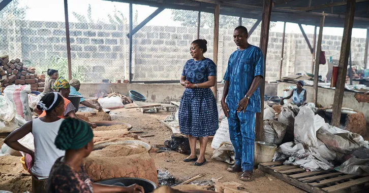 Workers drying spent brewery grain for poultry feed at Nation Feeders in Nigeria.
