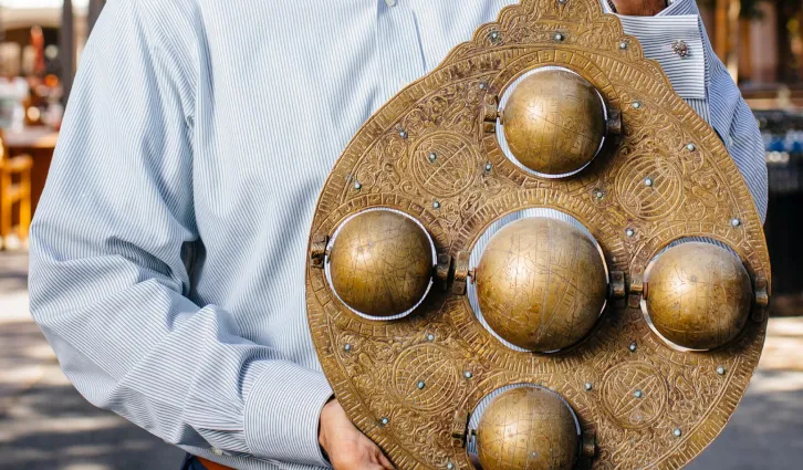 Saumitra Jha holds a brass astrolabe — a navigational tool used by medieval traders — that he bought while doing research in the port of Cochin, India.| Elena Zhukova