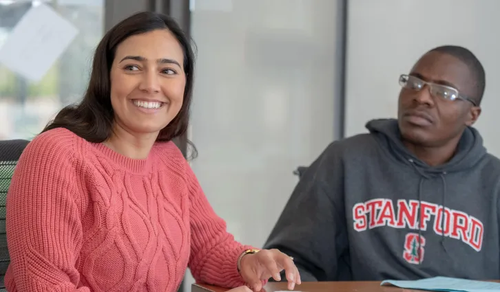 Sarah A. Martin looks up and smiles with fellow student in classroom. Credit: Linda A. Cicero / Stanford University News Service