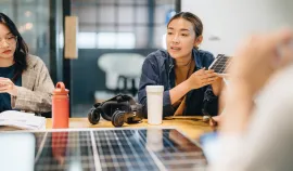 A group of young people working with solar panels in an office. Credit: iStock/staticnak1983