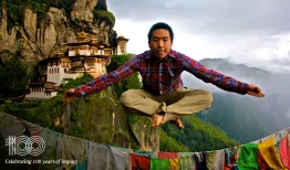 Stephen Lee jumps into a pose with the mountains of Bhutan in the background. Credit: Courtesy of Stephen Lee
