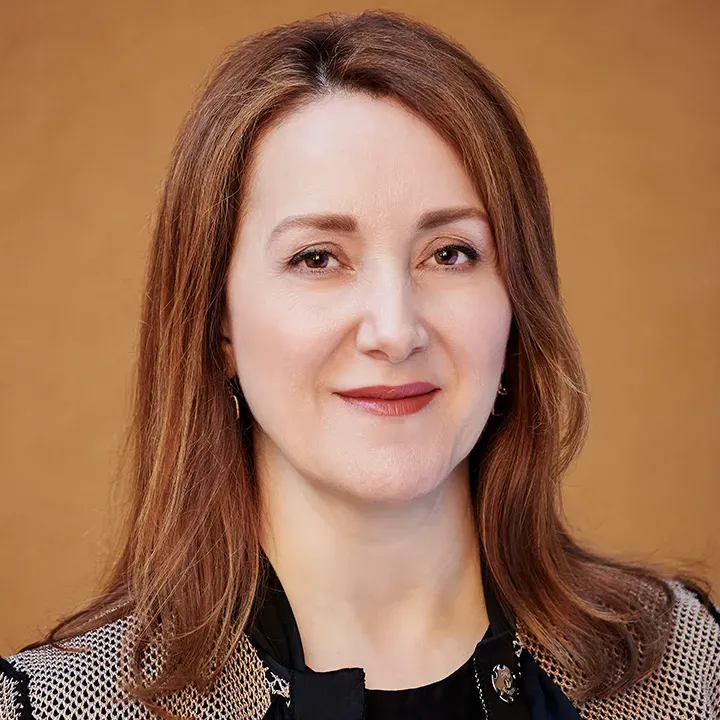 Noosheen Hashemi standing outdoors smiling, looking off camera. Credit: Winni Wintermeyer