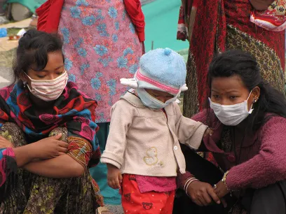 a little baby and two women with masks over their faces