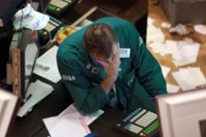 A NYSE trader with head in his hands