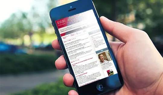 A hand holding a smartphone with the Executive Report email on it