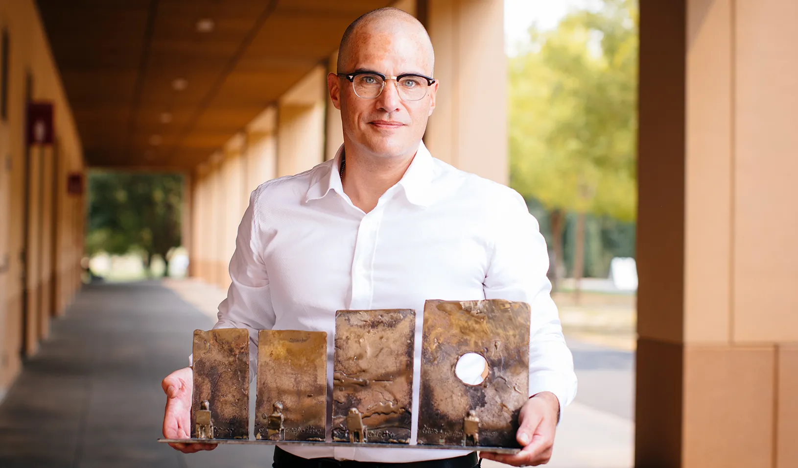 Christian Wheeler holding his bronze desk sculpture. Credit: Elena Zhukova