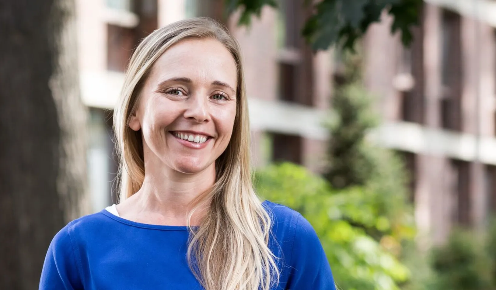Outdoor portrait of Renee Hirschberg smiling into the camera on a sunny day. |Credit: Rob Strong