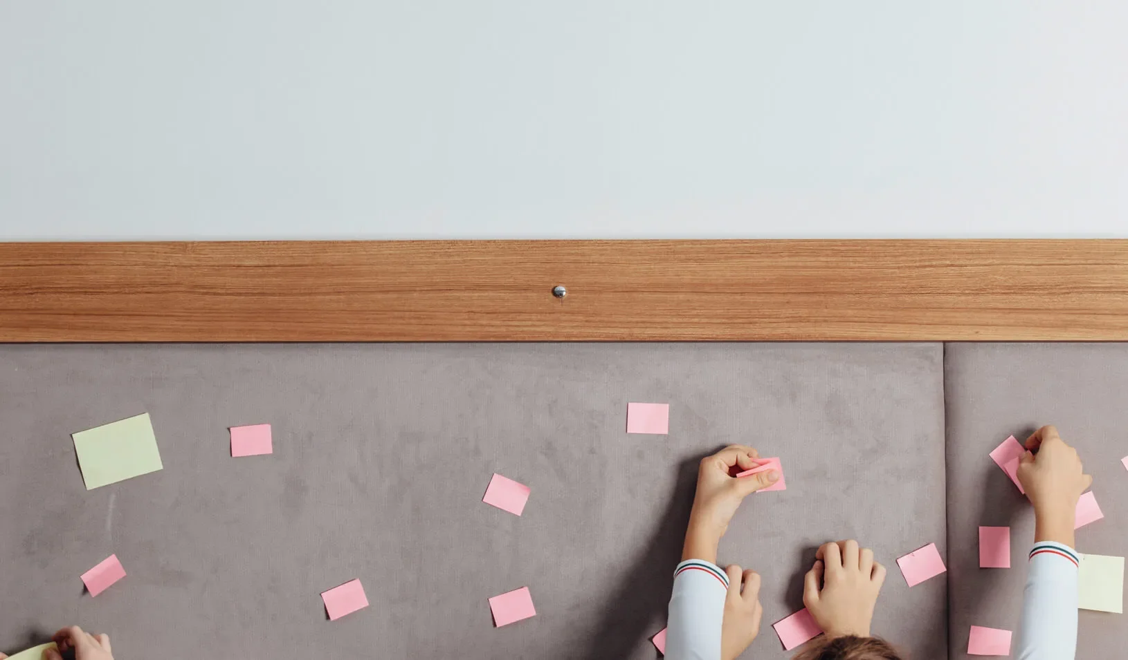A photograph of children putting post-its on a board. Credit: iStock/cometary