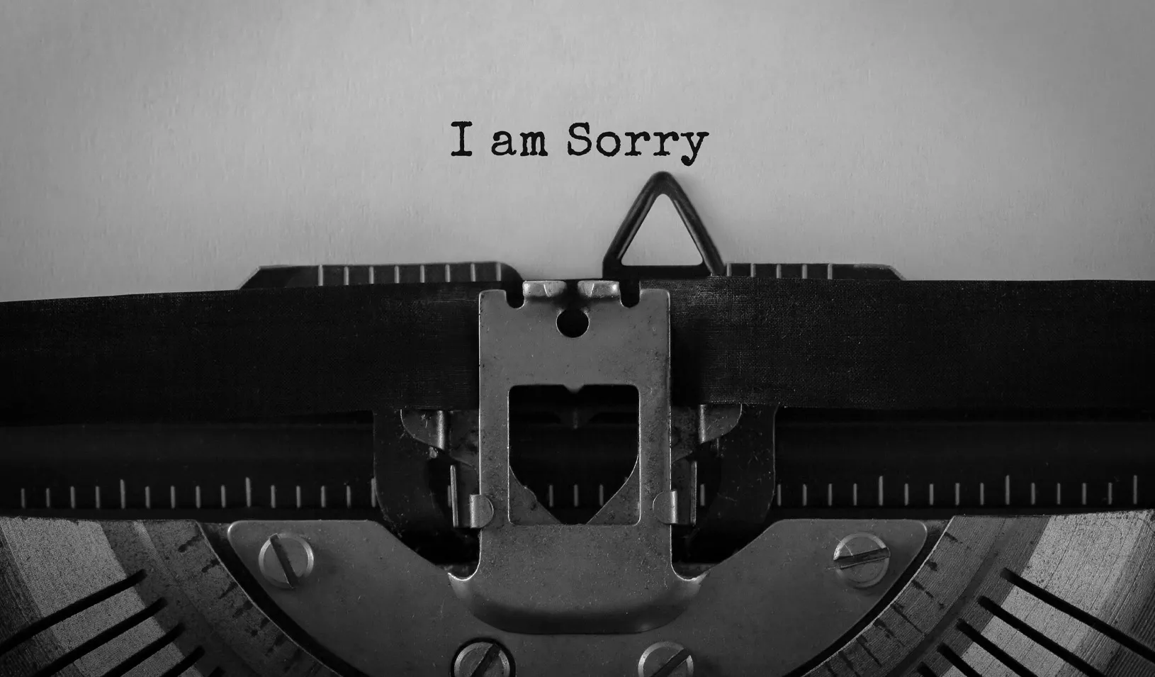 A photo of a retro typewriter with a piece of paper in it. On the paper are the words "I am sorry." Credit: iStock/Michail_Petrov-96
