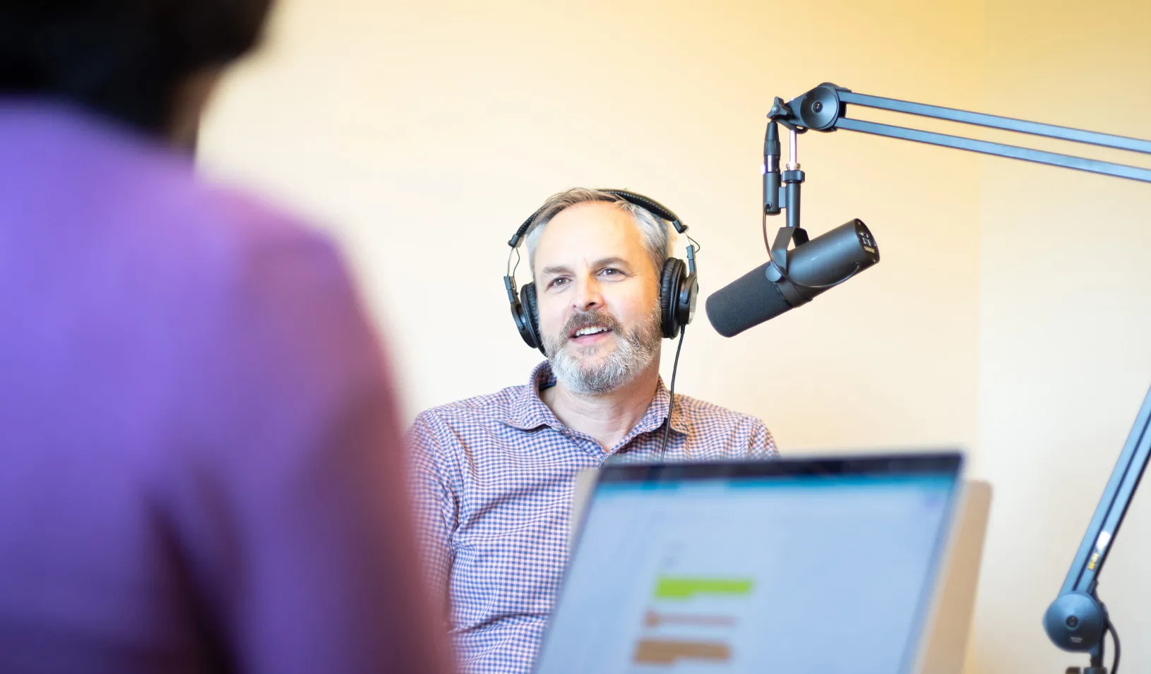 Photo of a man and a woman in a podcast studio. Credit: Tricia Seibold
