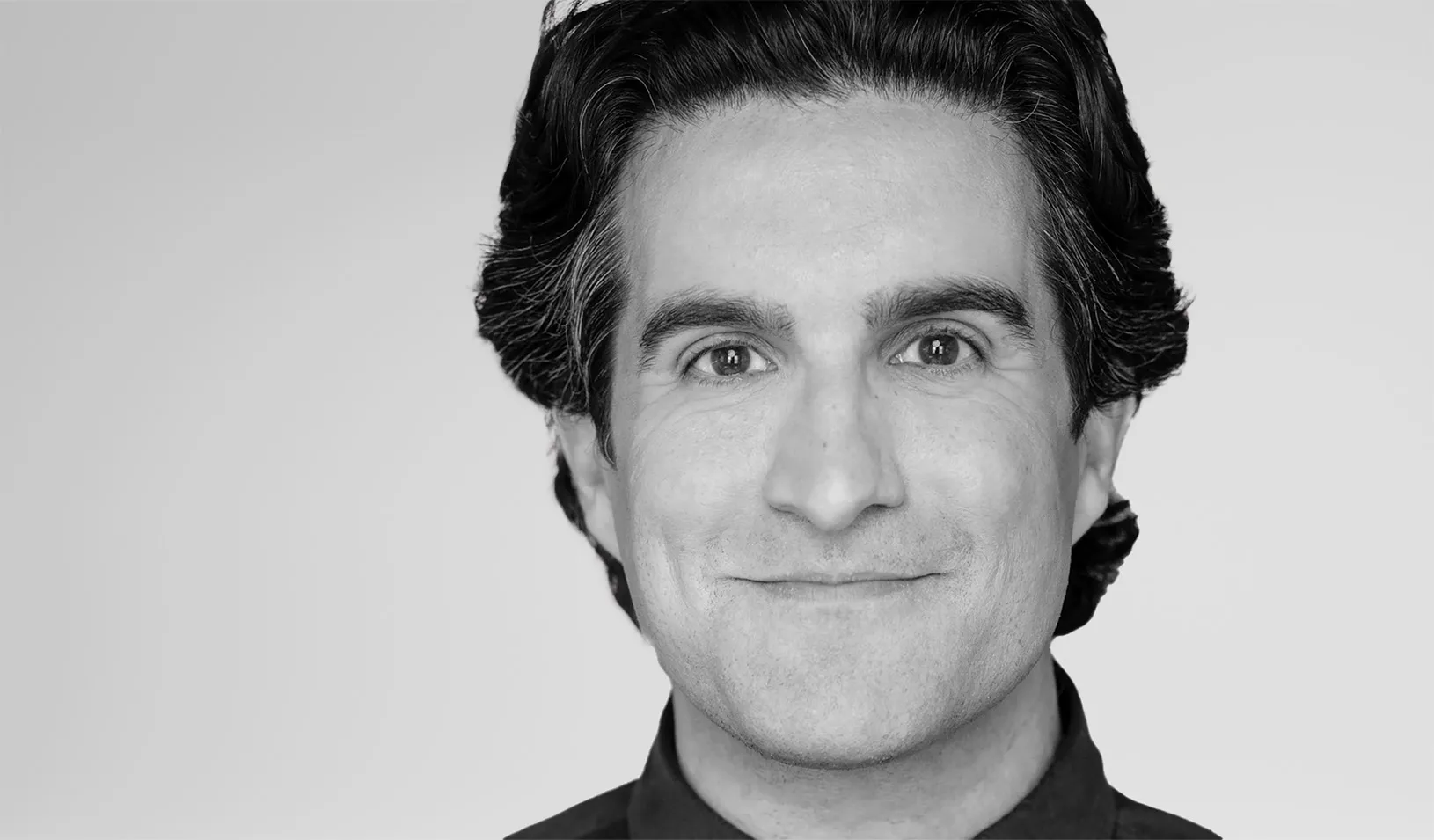 Black and white portrait of Andy Dunn smiling at the camera. Courtesy of Andy Dunn