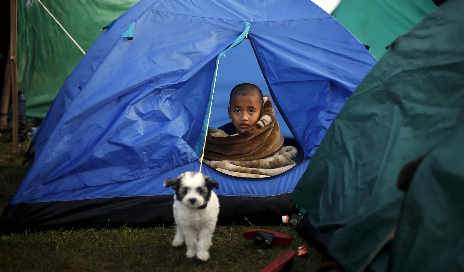 A boy sits inside a tent after a deadly earthquake in Nepal on April 29, 2015. | Reuters/Adnan Abidi
