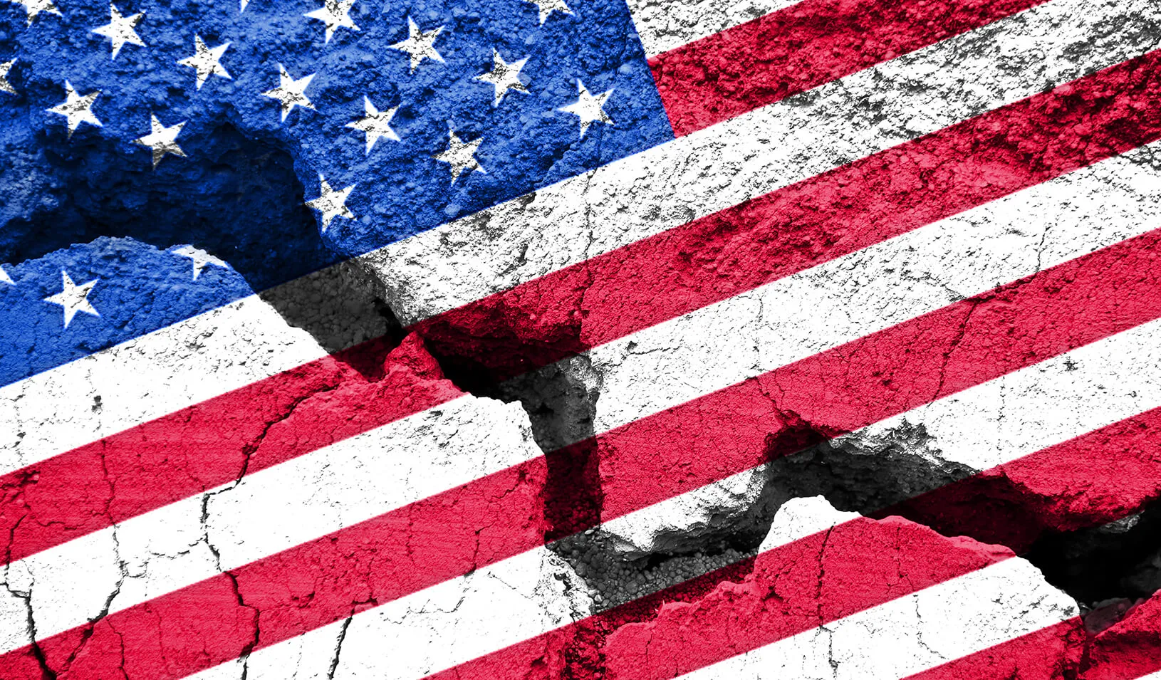 An american flag painted on cracked pavement | iStock/Delpixart