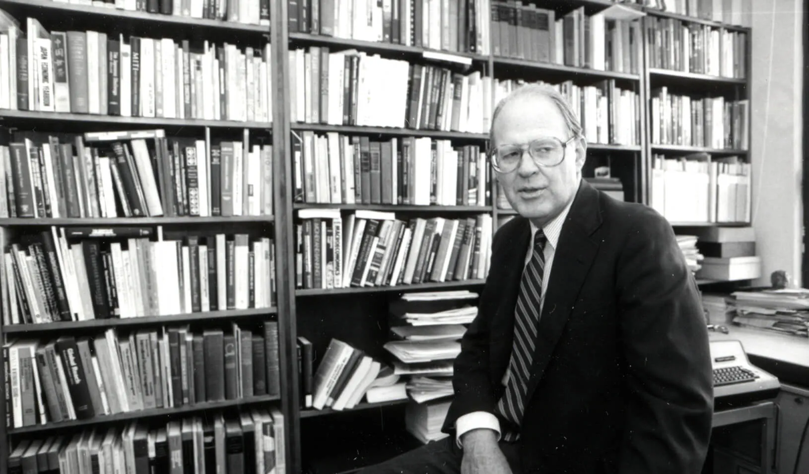 James E. Howell and bookcases full of books. Credit: Courtesy of Stanford Libraries Department of Special Collections & University Archives