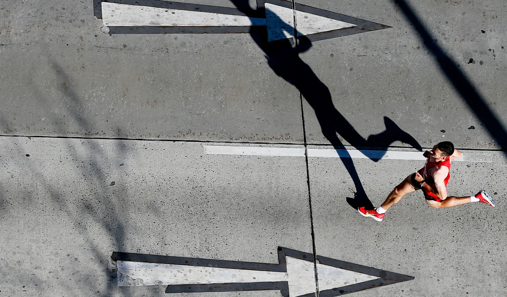 A runner going in the opposite direction of arrows on the road | Reuters/Leonhard Foeger