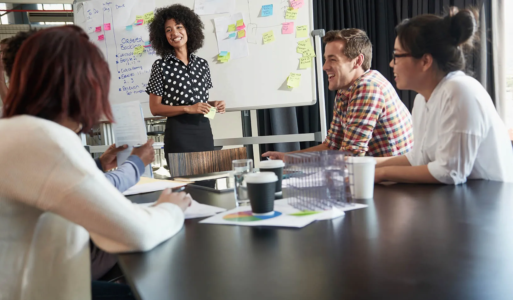 A confidant woman leads a group discussion | iStock/pixdeluxe