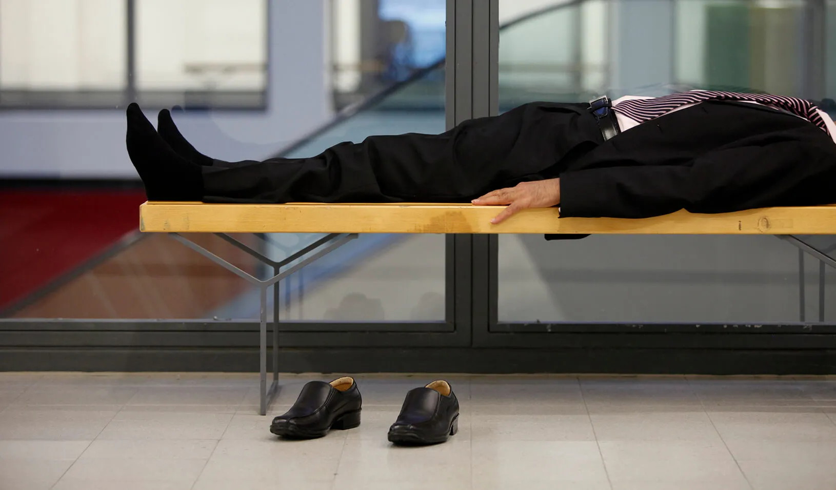 A man lays on a bench. | Reuters/Thomas Peter