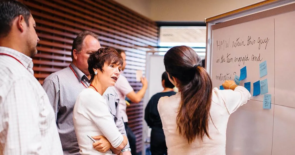Students confer at a whiteboard | Elena Zhukova