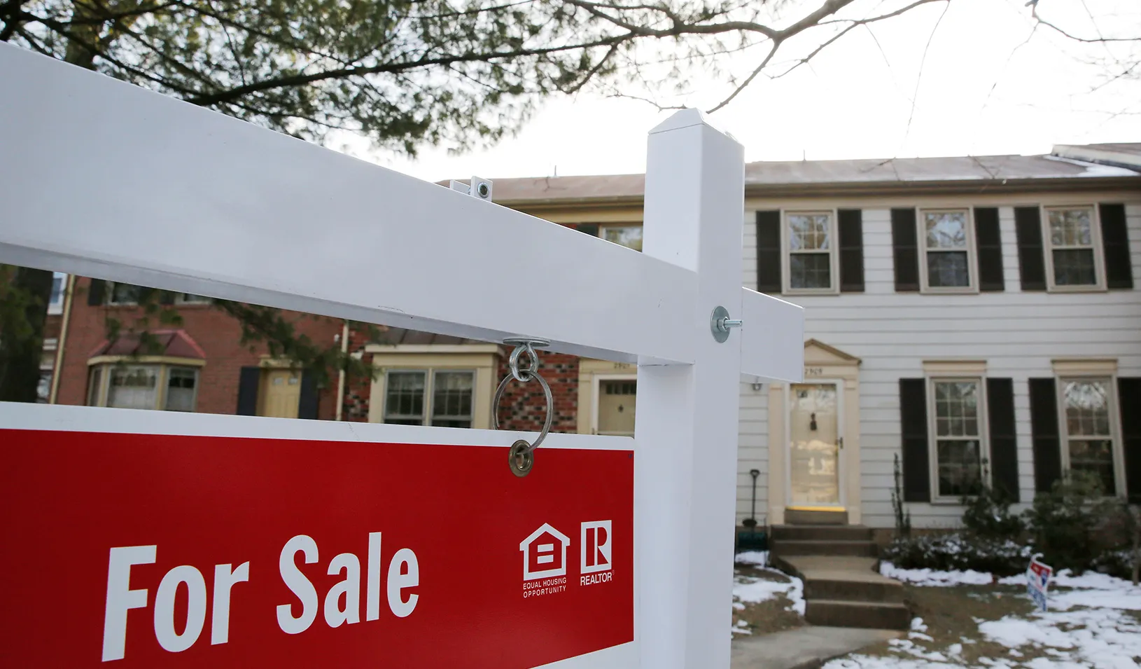 "For Sale" sign in front of home