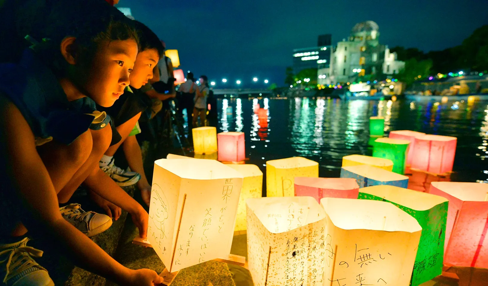 People release paper lanterns into river. | Reuters/Kyodo