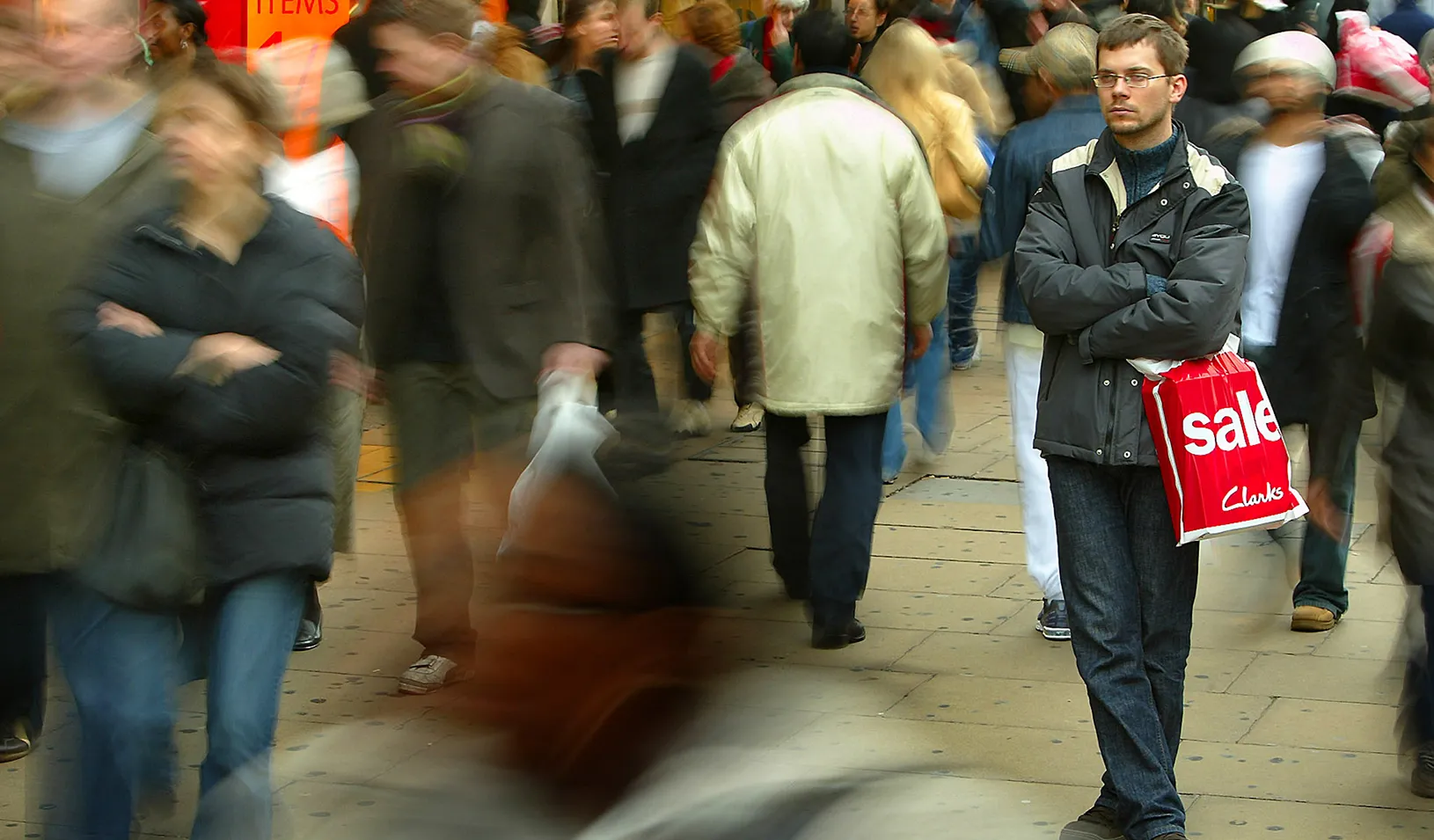 A shopper stands alone in a crowd.