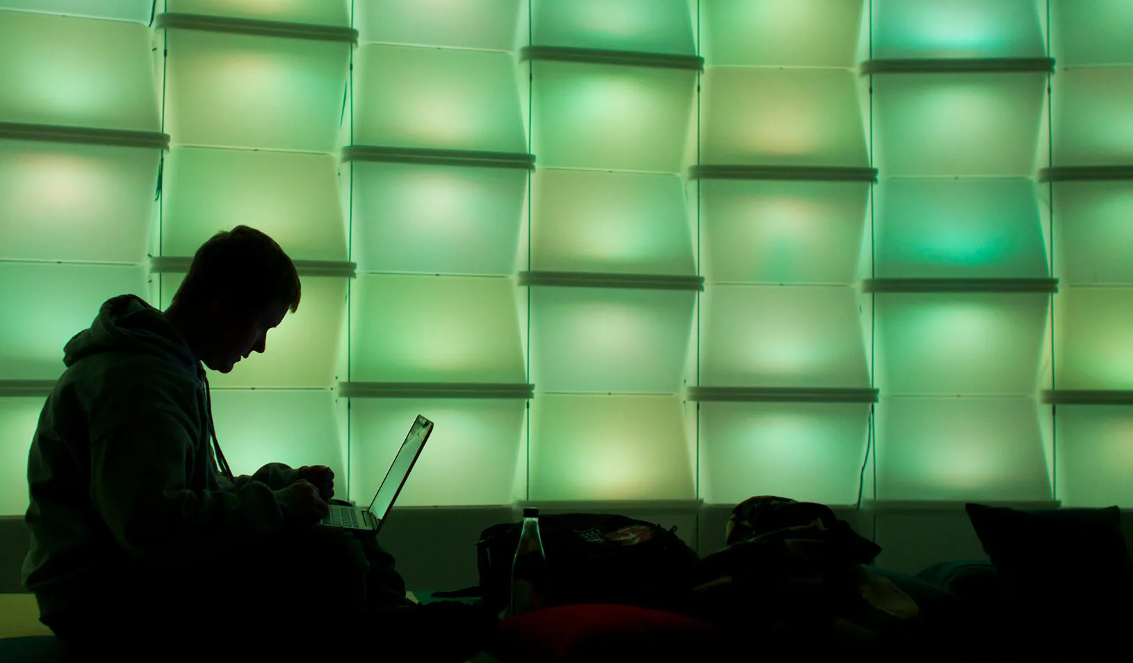 A woman uses a computer in a lounge area.