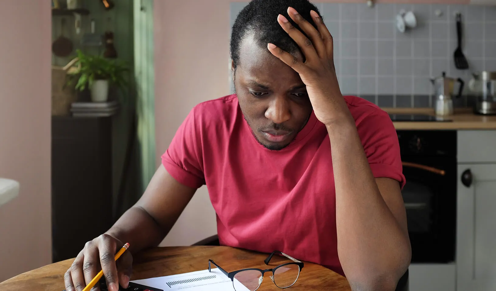 A young Black man, anxious about his bills. Credit: iStock/Damir Khabirov