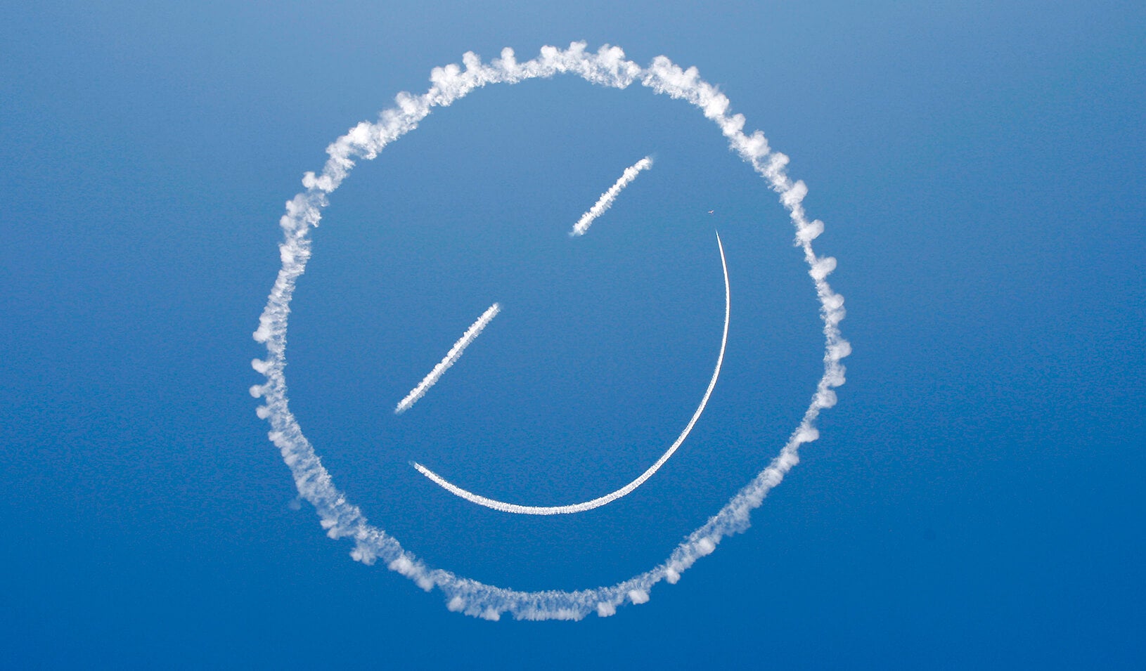 A plane "sky writes" a smiley face in the sky. | Reuters/David McNew